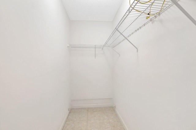 spacious closet with light tile patterned floors