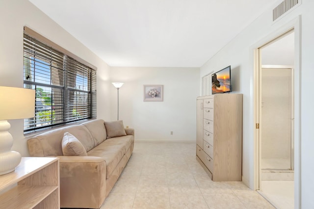 living area featuring baseboards, visible vents, and light tile patterned floors