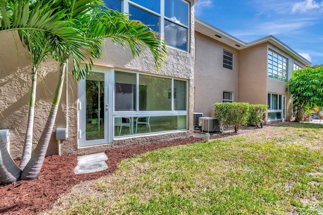 rear view of property with a lawn and stucco siding