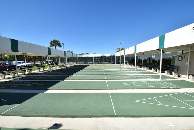view of property's community featuring shuffleboard and uncovered parking