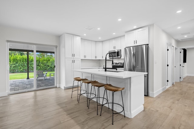1269 NW 4th St, Boca Raton, FL 33486 - kitchen with appliances with stainless steel finishes, a sink, baseboards, light wood-type flooring, and light countertops