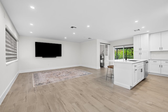 1269 NW 4th St, Boca Raton, FL 33486 - kitchen featuring a sink, white cabinetry, stainless steel dishwasher, light countertops, and a center island with sink