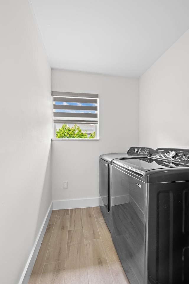 1269 NW 4th St, Boca Raton, FL 33486 - laundry room with washing machine and clothes dryer, light wood-style flooring, and baseboards
