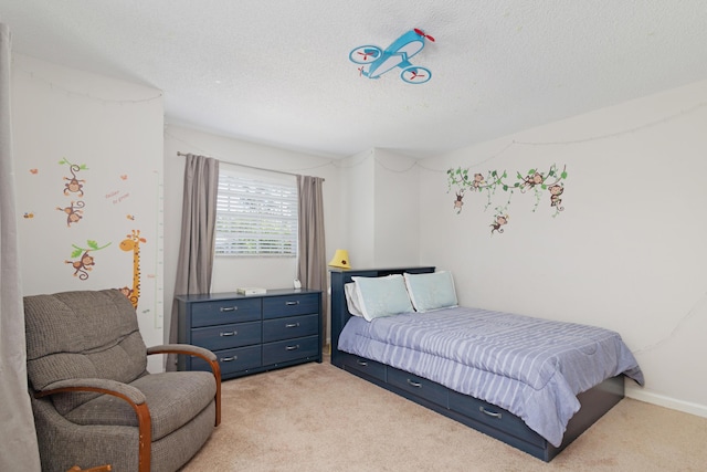 bedroom with light colored carpet and a textured ceiling