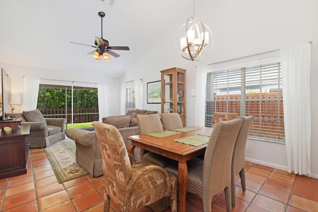 dining area with high vaulted ceiling, ceiling fan with notable chandelier, and light tile patterned flooring