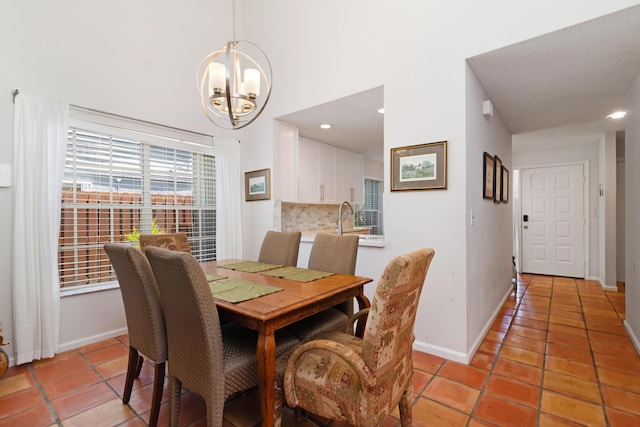 dining area with baseboards, a notable chandelier, light tile patterned floors, and a towering ceiling