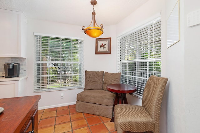 sitting room with baseboards, tile patterned floors, and a healthy amount of sunlight