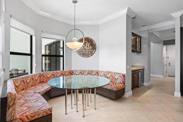 dining area with crown molding, wine cooler, light tile patterned flooring, baseboards, and breakfast area
