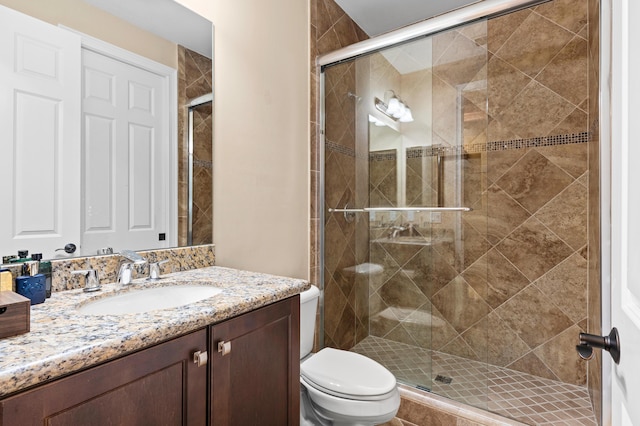 bathroom featuring vanity, a stall shower, and toilet