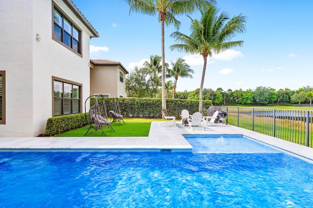 view of pool featuring a fenced in pool, a patio area, fence, and a yard