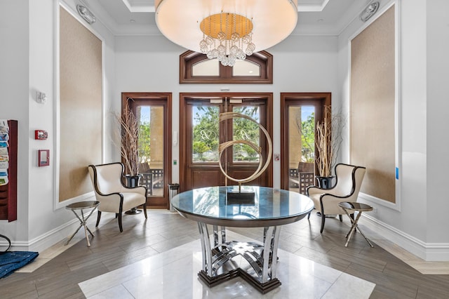 living area with baseboards, ornamental molding, and plenty of natural light