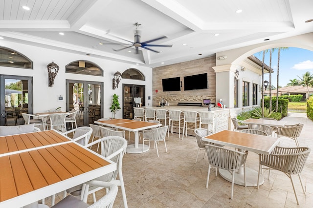 view of patio / terrace with an outdoor bar, a ceiling fan, and outdoor dining space