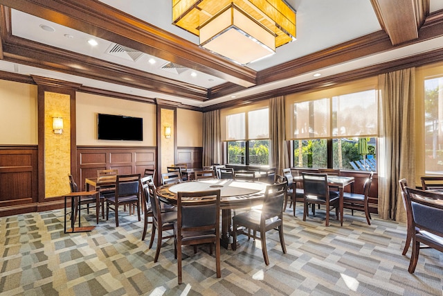 dining area featuring light colored carpet, a decorative wall, visible vents, ornamental molding, and coffered ceiling