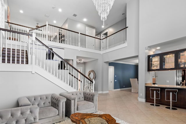 living room with a high ceiling, a notable chandelier, bar, stairs, and baseboards
