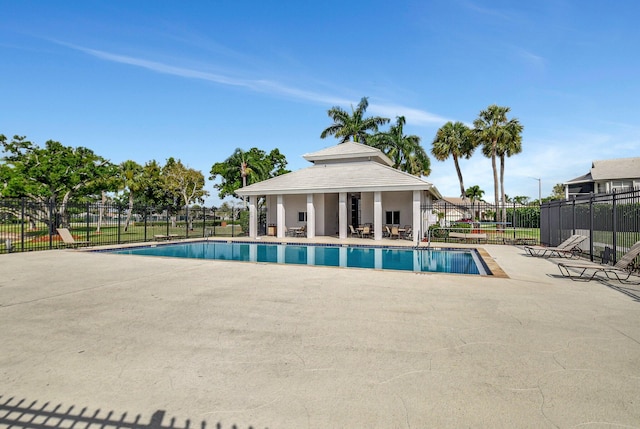 community pool with a patio and fence