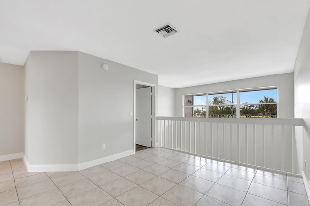 tiled empty room with visible vents and baseboards