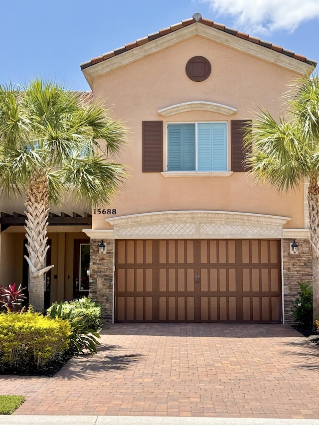 15688 Italian Cypress Way, Wellington, FL 33414 - mediterranean / spanish house featuring decorative driveway, stone siding, and stucco siding