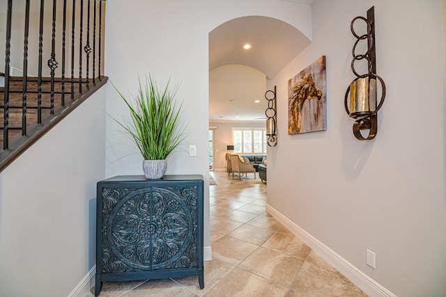 15688 Italian Cypress Way, Wellington, FL 33414 - corridor with light tile patterned flooring, arched walkways, recessed lighting, baseboards, and stairway