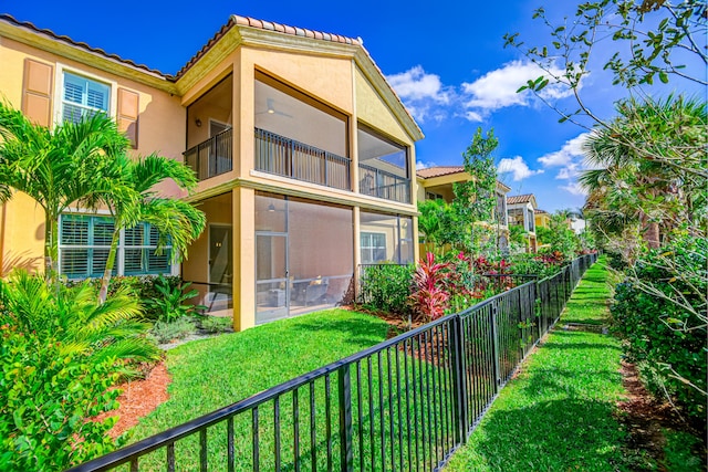 15688 Italian Cypress Way, Wellington, FL 33414 - back of house with a yard, a fenced backyard, a sunroom, and stucco siding