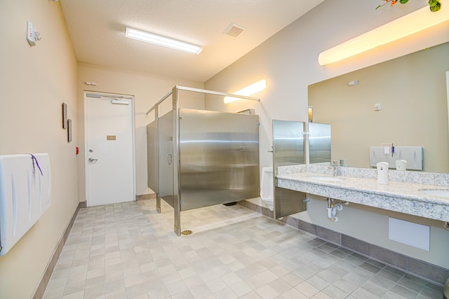 15688 Italian Cypress Way, Wellington, FL 33414 - bathroom featuring double vanity, a textured ceiling, a stall shower, a sink, and baseboards