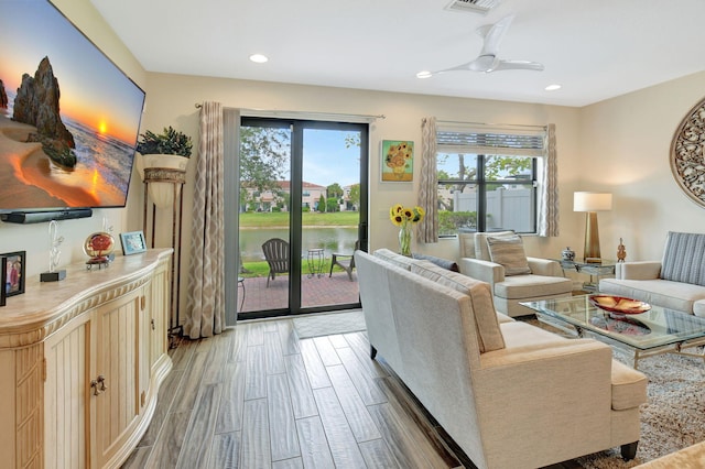 living area with wood tiled floor, plenty of natural light, a ceiling fan, and recessed lighting
