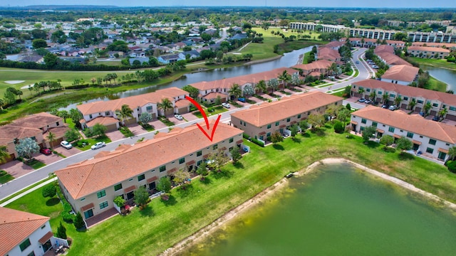 drone / aerial view with a water view, view of golf course, and a residential view