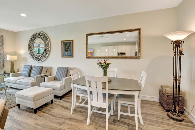 living area featuring recessed lighting, light wood-style flooring, and baseboards