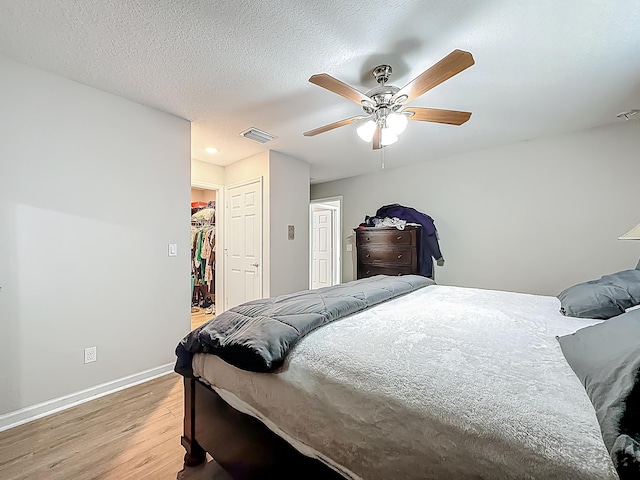 1679 SW Cameo Blvd, Port Saint Lucie, FL 34953 - bedroom with light wood finished floors, baseboards, visible vents, a spacious closet, and a ceiling fan