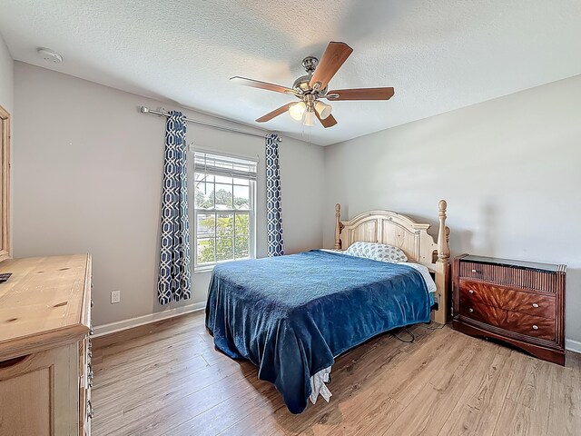 1679 SW Cameo Blvd, Port Saint Lucie, FL 34953 - bedroom featuring light wood-style flooring, baseboards, a textured ceiling, and ceiling fan