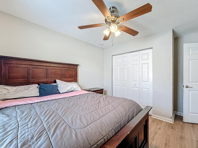 1679 SW Cameo Blvd, Port Saint Lucie, FL 34953 - bedroom featuring a textured ceiling, light wood-type flooring, baseboards, a ceiling fan, and a closet