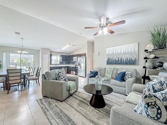 1679 SW Cameo Blvd, Port Saint Lucie, FL 34953 - living room featuring lofted ceiling, ceiling fan with notable chandelier, plenty of natural light, and light tile patterned floors