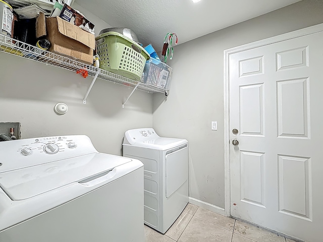 1679 SW Cameo Blvd, Port Saint Lucie, FL 34953 - washroom featuring washing machine and dryer, baseboards, laundry area, and light tile patterned floors