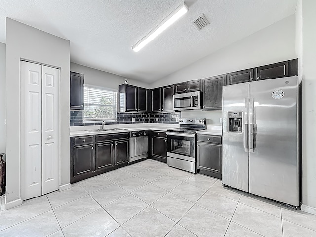 1679 SW Cameo Blvd, Port Saint Lucie, FL 34953 - kitchen with dark cabinets, stainless steel appliances, visible vents, and a sink
