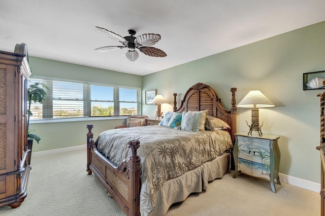 bedroom with light colored carpet, baseboards, and ceiling fan