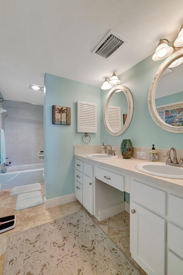 bathroom featuring double vanity, a washtub, visible vents, and a sink