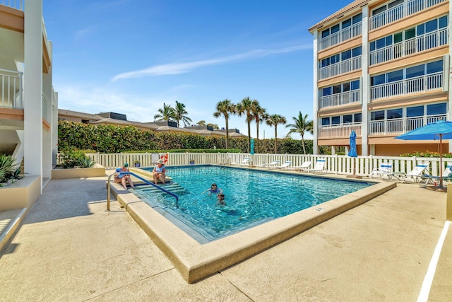 community pool featuring fence and a patio area