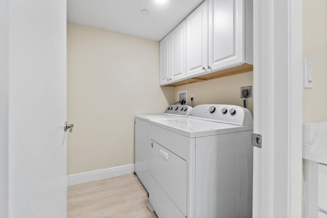 laundry room with separate washer and dryer, cabinet space, baseboards, and light wood-type flooring