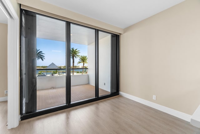 unfurnished room featuring baseboards and wood finished floors