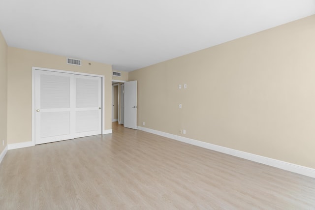 unfurnished bedroom with baseboards, visible vents, and light wood-type flooring
