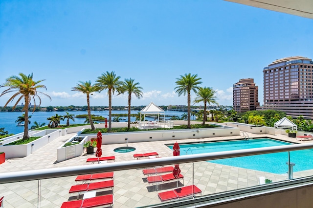 community pool featuring a gazebo, a water view, and a patio area