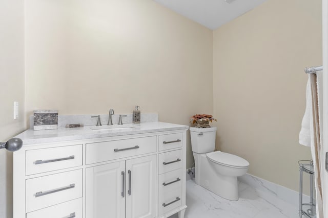 bathroom with vanity, toilet, and marble finish floor