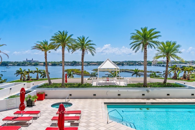 community pool with a water view and a patio area