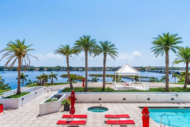 community pool with a patio and a water view