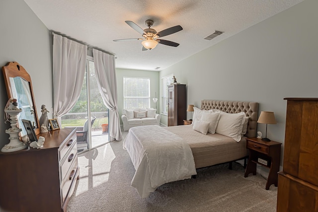bedroom with visible vents, carpet floors, access to exterior, a textured ceiling, and a ceiling fan