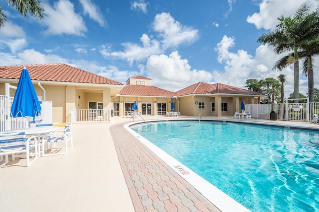 pool featuring fence and a patio area