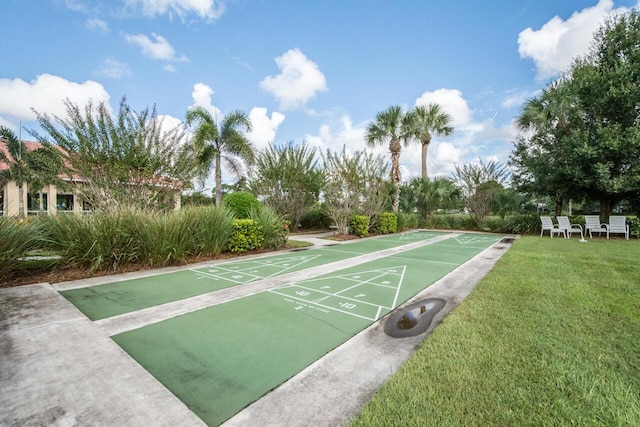 view of property's community featuring shuffleboard and a yard