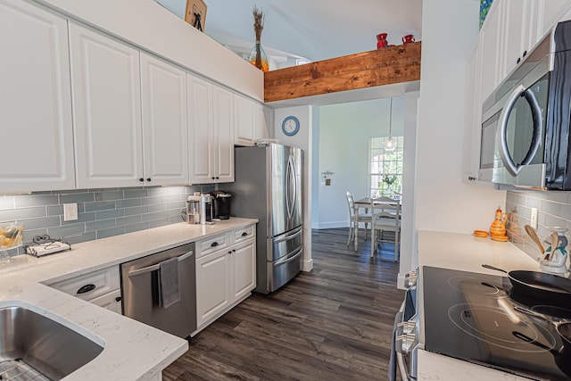 kitchen featuring appliances with stainless steel finishes, white cabinets, dark wood-style flooring, and tasteful backsplash