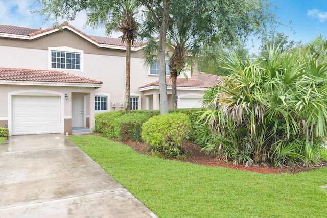 view of front of home with a tile roof, a front yard, stucco siding, and driveway