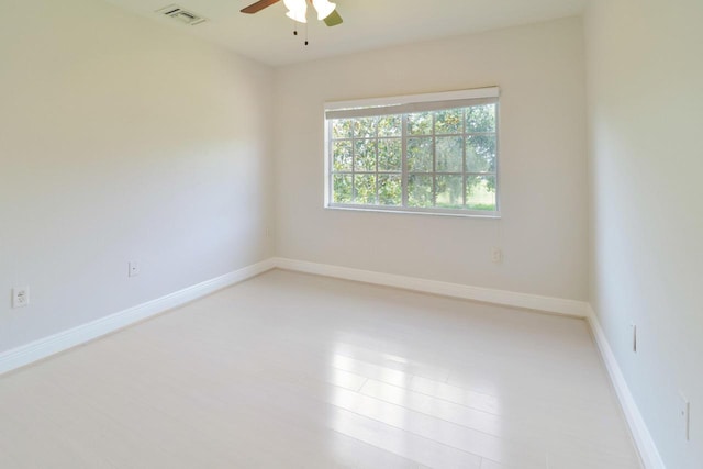 empty room with light wood-style floors, visible vents, baseboards, and ceiling fan