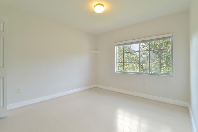 empty room featuring light wood finished floors and baseboards